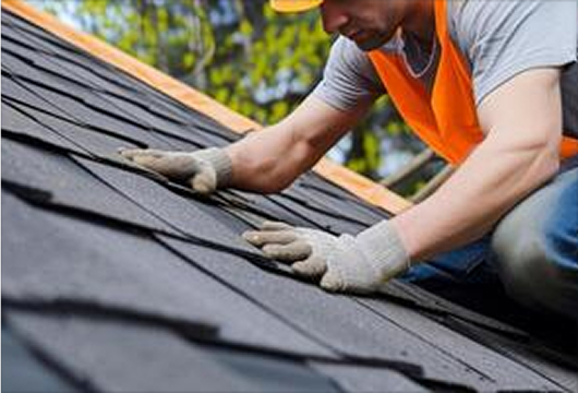 Roofer repairing an asphalt shingle roof